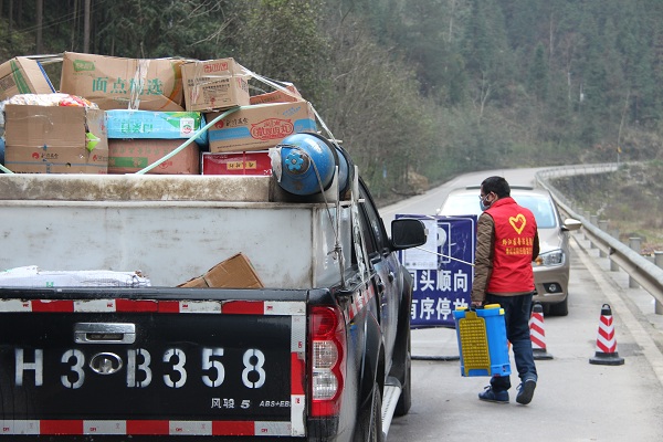 2重慶黔江區(qū)與湖北省咸豐縣大路壩交界疫情檢測全返點，司法局工作人員陳兵為兩省過往物資車輛消毒，兩省（市）工作人員共同戰(zhàn)“疫”.jpg